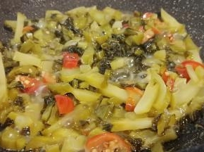 锅里留一点底油，下蒜泥炒香、再放酸菜、泡椒翻炒。