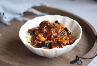 把煮熟的面放入大碗里，浇上步骤23的卤，再放些菜吗，拌一拌就可以开吃了。