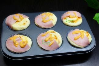 把圆火腿对半切开，每天面团上铺上火腿片，然后挤一些千岛酱在表面。