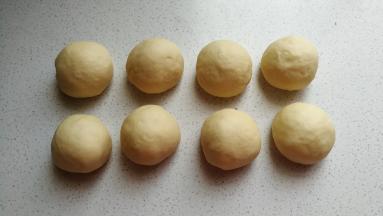 发酵好的面团取出挤压揉搓排气，然后分成均匀的八个剂子滚圆，盖保鲜膜静置醒发十分钟左右。