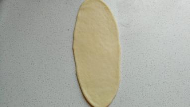 取一份醒发好的面团擀成长舌状。