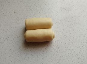 擀好后从两端向中间卷起，卷好后摆入烤盘。