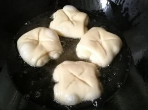 锅中倒入适量油，烧至五成热后开小火，放入面包卷开始小火炸制。