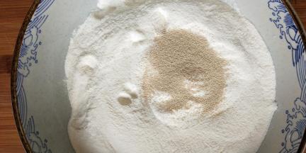 面粉里倒入酵母并用手搅拌均匀