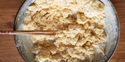 把鸡蛋混合液倒入面粉中，用筷子搅拌成雪花状