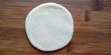 取一个小剂子擀开成1cm厚的圆形。把其余的面团一块擀完。发保鲜膜醒发15-20分钟左右至有轻微轻盈感，不要发的过大。