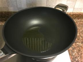 热锅倒油烧至八成热。