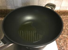 热锅倒油烧至八成热。