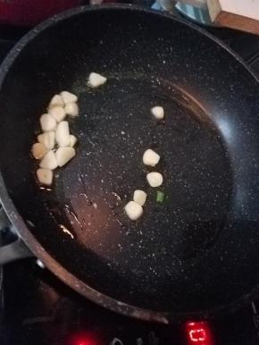 蒜瓣切片，加入热油中炒香，家里有姜的话，炒点姜丝更佳。