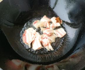 热锅凉油放入五花肉和一颗八角煸炒。