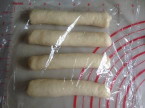 从上往下卷起，卷成长条状，盖上保鲜膜，松驰5-10分钟