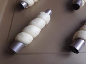 将松驰后的面团搓长到32-34CM左右，缠绕在管上几圈，收口要收好，以防发酵和烘烤时脱离。放在不粘烤盘上，放入东菱K40C烤箱，选择发酵档36度，时间40分钟左右