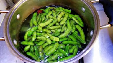 然后放入毛豆不加盖煮开后转中火煮8分钟