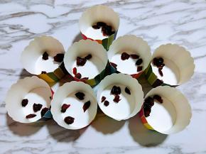 准备好纸杯首先放入蔓越莓干。拌好的蛋糕糊，细腻光滑，饱满，倒入纸杯中。