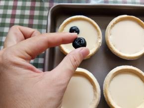 把混合液倒入塔皮八九分满，然后每个挞里面放入三四个洗净的蓝莓