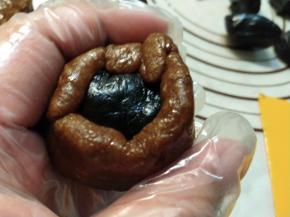 上面放上一块搓好的馅料，一点一点慢慢收紧，一定注意要馅料跟皮完全贴紧，不要包进空气。