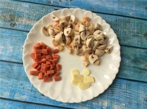 将蘑菇和火腿肠切小颗粒，大蒜切片。