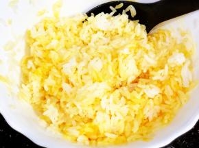 米饭中放入适量的盐，少许鸡粉、蛋黄拌匀，备用