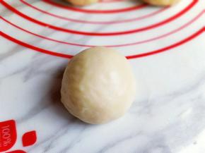 取一个面团，再次轻轻的按排气，再揉圆。