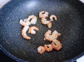 平底锅中加入食用油，倒入虾仁。