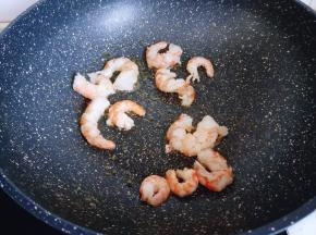 平底锅中加入食用油，倒入虾仁。