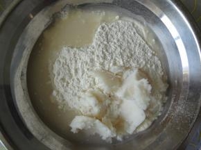 将水油皮材料称量好放进盆里揉成团，取出放在揉面垫上像揉面包那样搓揉