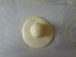 水油皮用手按扁，中间厚边缘薄，放上油酥用虎口慢慢往上收捏紧收口向下