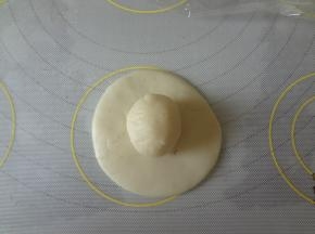 水油皮用手按扁，中间厚边缘薄，放上油酥用虎口慢慢往上收捏紧收口向下