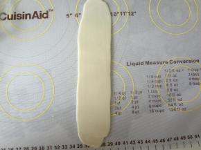 然后再次擀成牛舌状，轻轻的自上而下卷起来