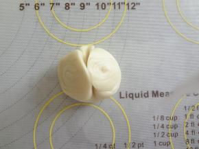 松弛好的酥皮轻轻的在中间压痕用手两端向中间捏合压扁