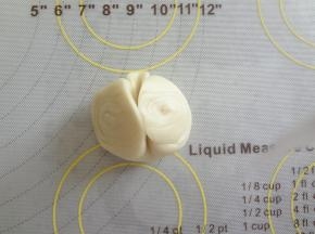 松弛好的酥皮轻轻的在中间压痕用手两端向中间捏合压扁