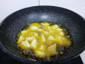 起油锅，油温8成时加入豆果，中小火炸薯块。