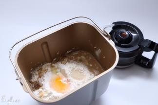 把中种食材一同放入面包桶。酵母在面粉中挖一个小坑放入。