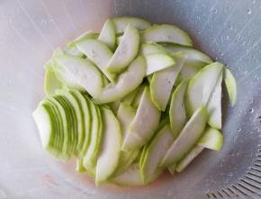 瓠瓜去头尾，刮皮洗净切薄片。