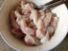 时间到了以后再酌情放入大概2勺淀粉，拌匀，状态如图，就是每条肉上都均匀挂满面糊的感觉