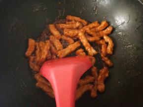 锅中放入一点底油，下调好的酱料小火烹至冒泡，放入炸好的里脊翻炒