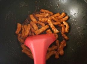 锅中放入一点底油，下调好的酱料小火烹至冒泡，放入炸好的里脊翻炒