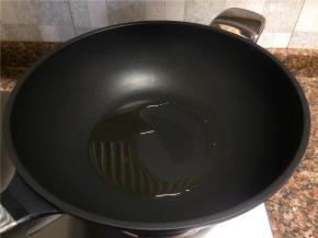 热锅倒油烧至八成热。