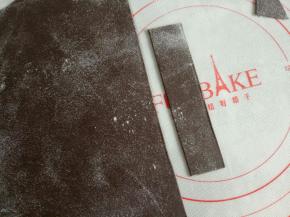 剩下的黑色面团重新揉一下擀成薄片，切大概2-3厘米宽的长条