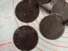 黑色面团重新揉一下，擀薄片，用合适的圆形模具或者盖子压出圆形薄片来