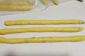 发好的面团三个一组，分别搓成细长的圆条。