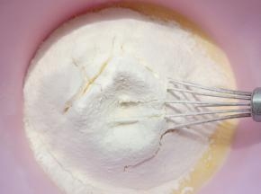 倒入牛奶，淡奶油搅拌均匀后，筛入低筋面粉、玉米淀粉、奶粉搅拌均匀。
