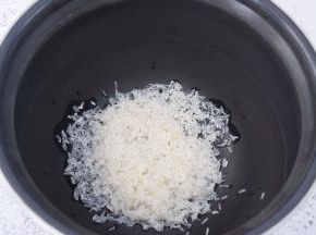 把淘洗干净的大米倒入电饭煲内胆