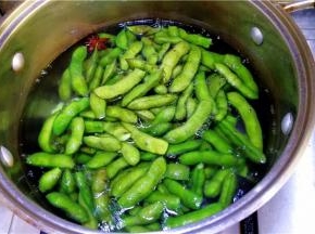 然后放入毛豆不加盖煮开后转中火煮8分钟