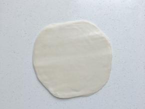 先按扁再用擀面棍擀成比手掌大，大约直径16厘米左右的薄片状（此时擀的时候会有多余的油溢出，正常现象，也不要擀太大，撕的时候会破，我做了40张春卷皮，无一破损，按照婧妞的方法来你也可以）