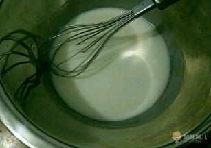 准备两个无水无油的不锈钢盆，一个放入牛奶和玉米油，混合均匀后搅打至乳化。