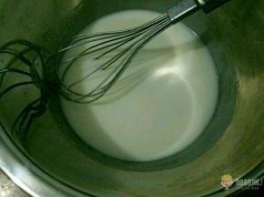 准备两个无水无油的不锈钢盆，一个放入牛奶和玉米油，混合均匀后搅打至乳化。