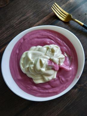 把奶油倒入紫薯泥里，继续用手动打蛋器打到均匀，然后装入裱花袋里，绑紧袋口。