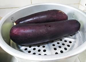 蒸锅里烧开水，然后放入去头尾洗干净的茄子。