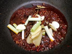 加入姜蒜片，蒜白，八角，桂皮，香叶，干辣椒干花椒翻炒片刻